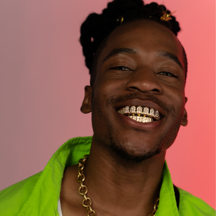 Man laughing and showing gild grillz which are customized by Houston Bling