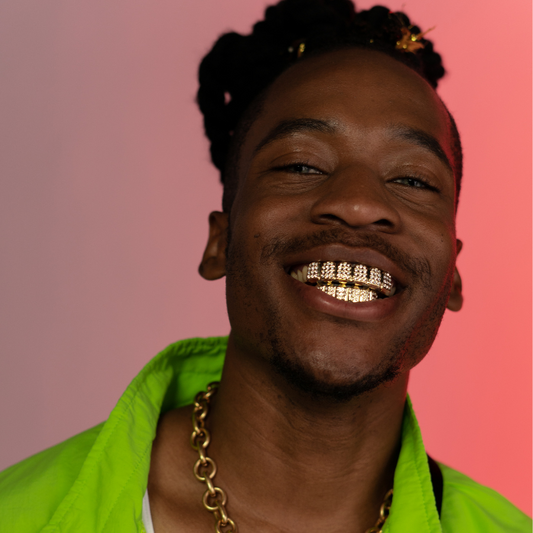 Man laughing and showing gild grillz which are customized by Houston Bling